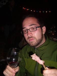 Man eating lamb and drinking wine in a restaurant